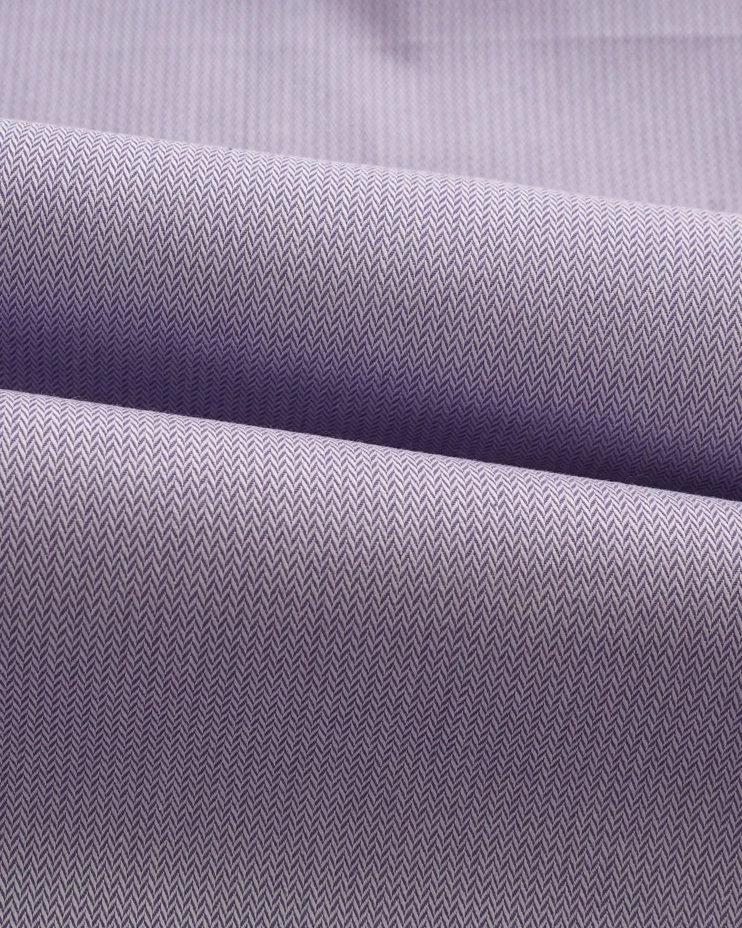 Swatch of lavender herringbone cotton fabric showing intricate weave pattern