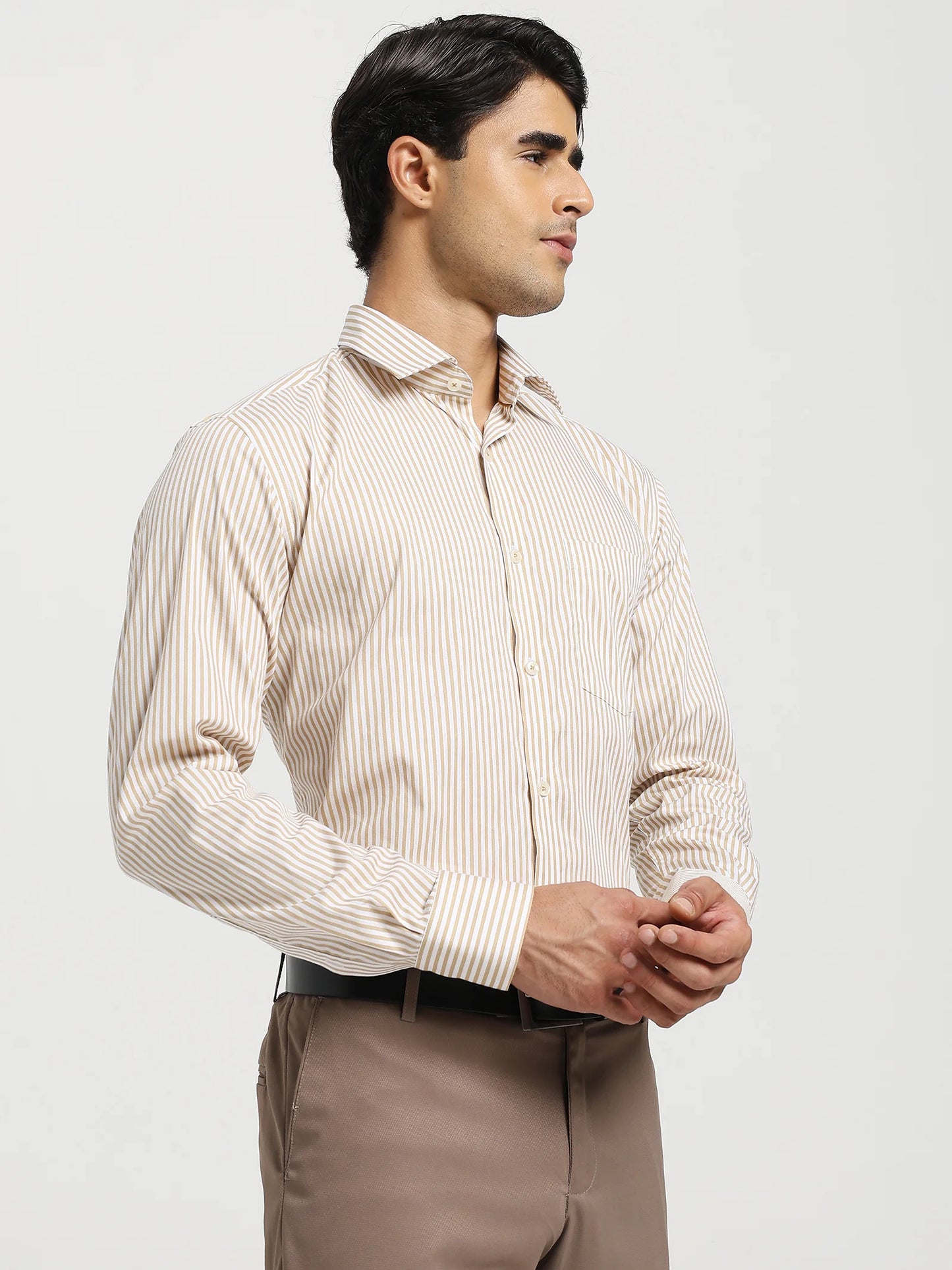 Man wearing a beige striped shirt and brown pants on a white background