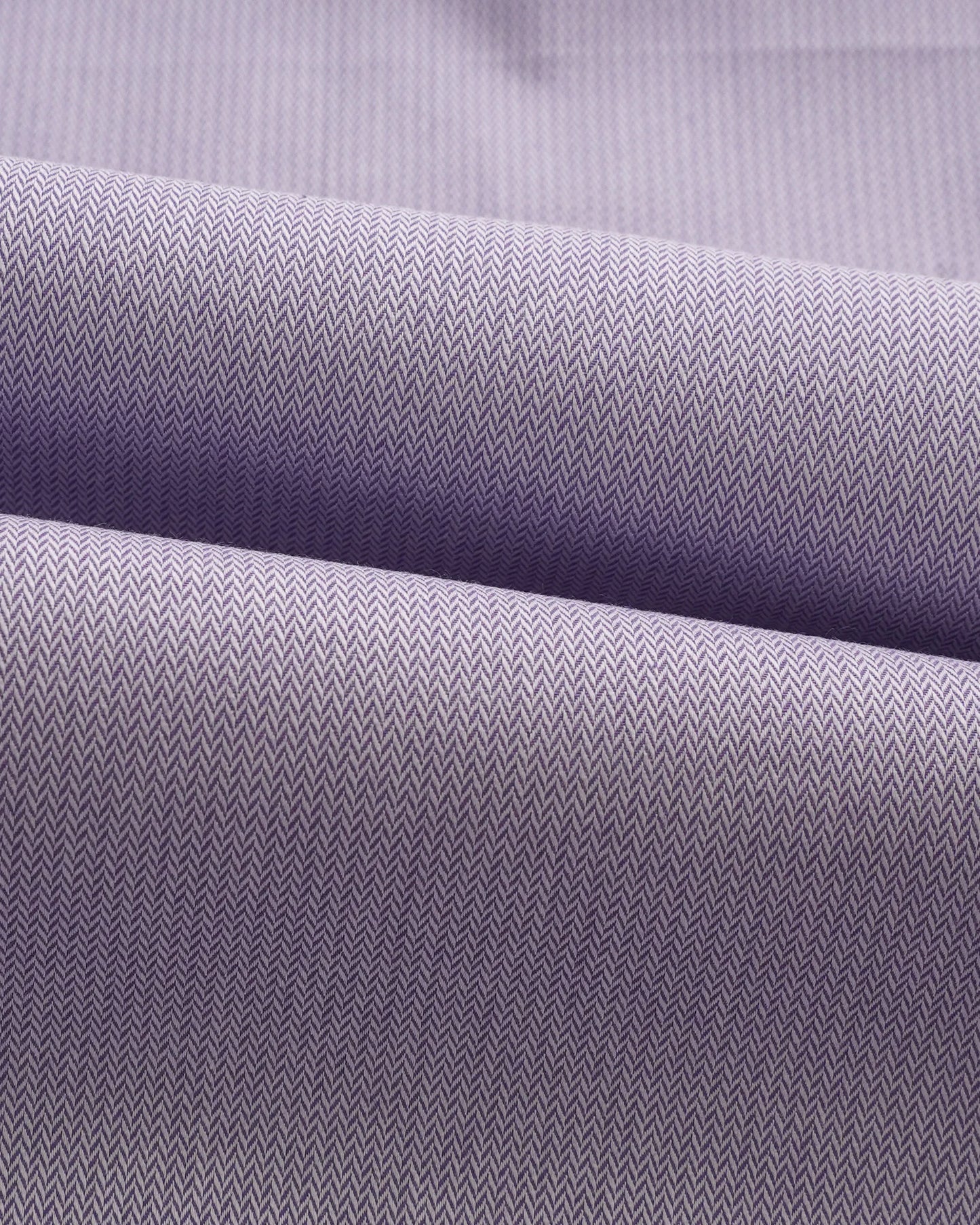 Swatch of lavender herringbone cotton fabric showing intricate weave pattern
