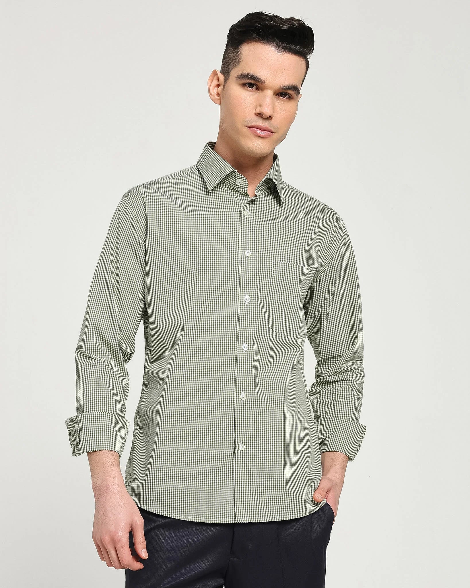 Man wearing a green checkered shirt against a plain background
