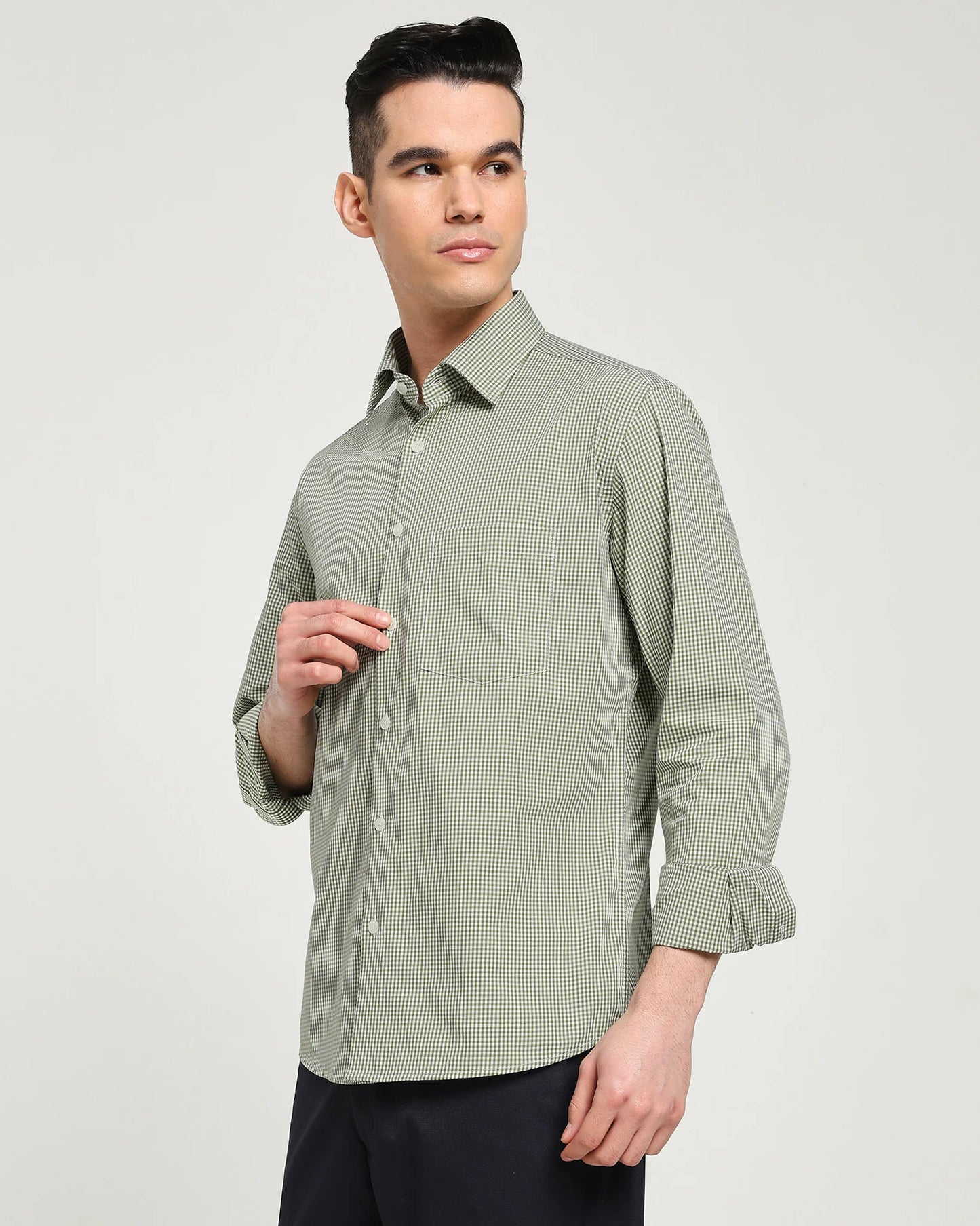 Man wearing a green checkered shirt against a plain background
